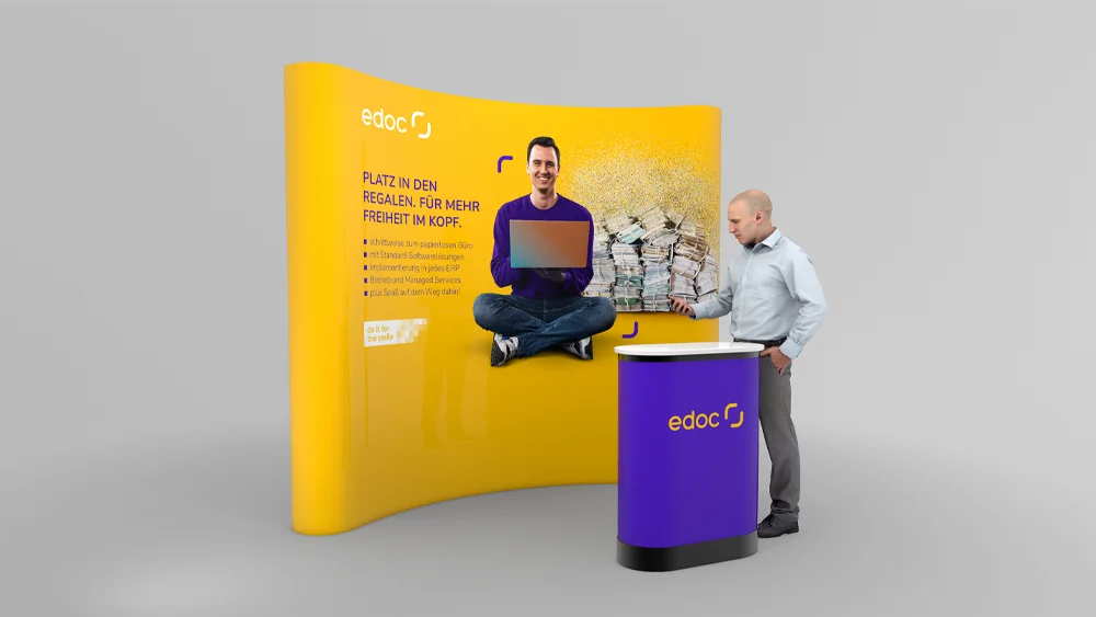 Kleiner Messestand mit Wand und Stehtisch für Rebranding, mann steht am Stehtisch
