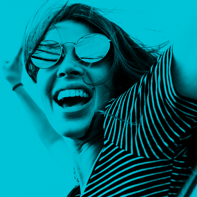 Frau mit Sonnenbrille lacht in die Kamera für Markenlaunchkampagne